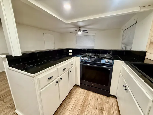a kitchen with granite countertop a stove and a sink