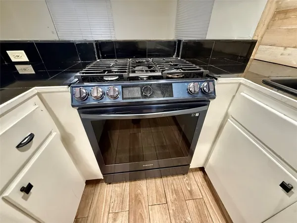 a stove top oven sitting inside of a kitchen