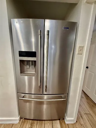 a metallic refrigerator freezer sitting in a kitchen