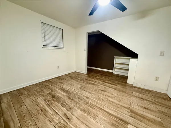 a view of empty room with wooden floor
