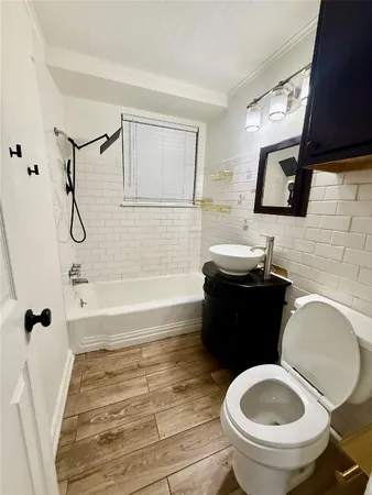 a bathroom with a granite countertop toilet sink and mirror