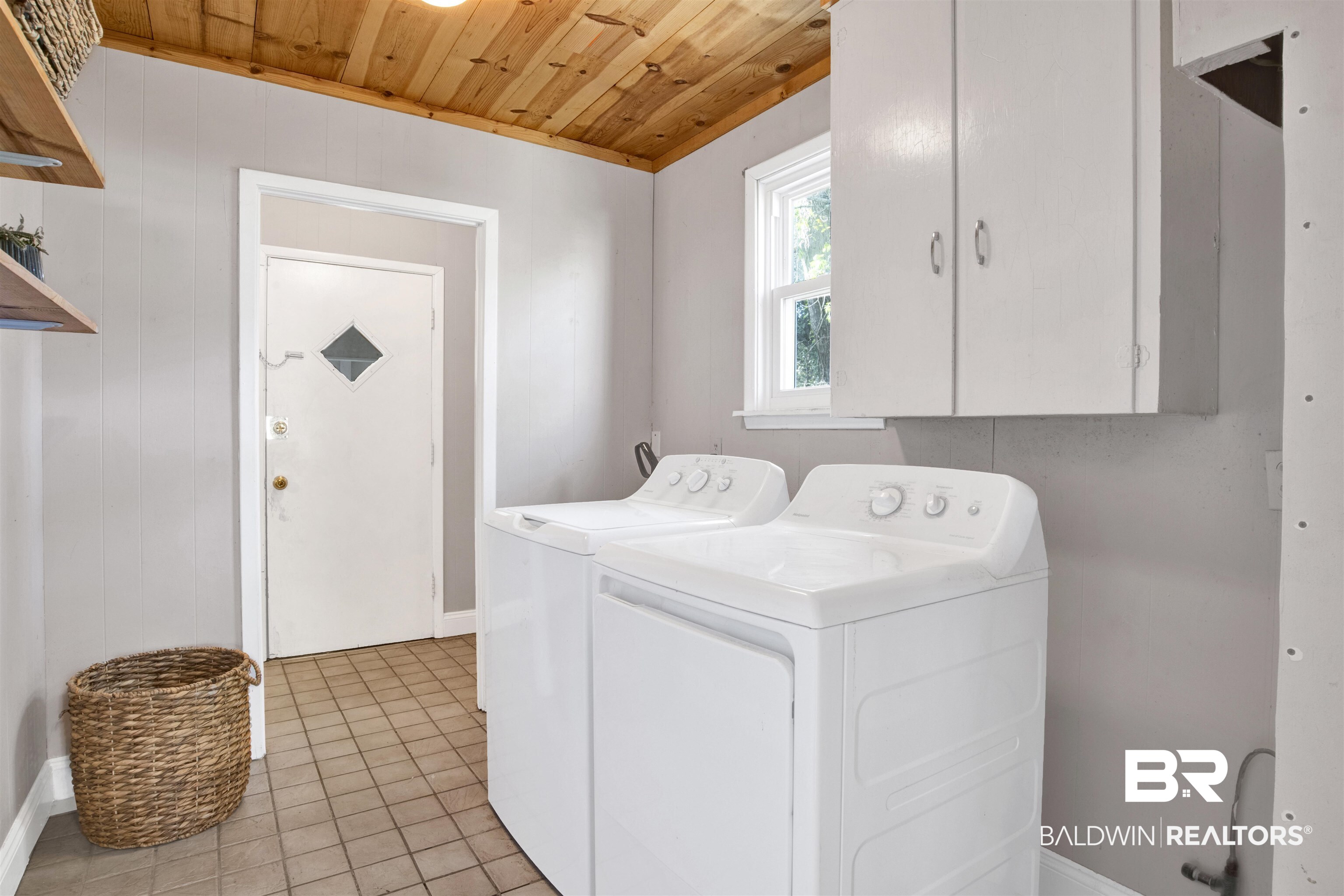 160 Emogene Place Mobile, AL 36606 - Photo 26 of 32 Laundry area with wood ceiling, cabinet space, washing machine and dryer, and light tile patterned flooring