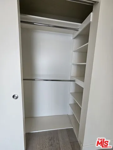 a view of walk in closet with empty racks