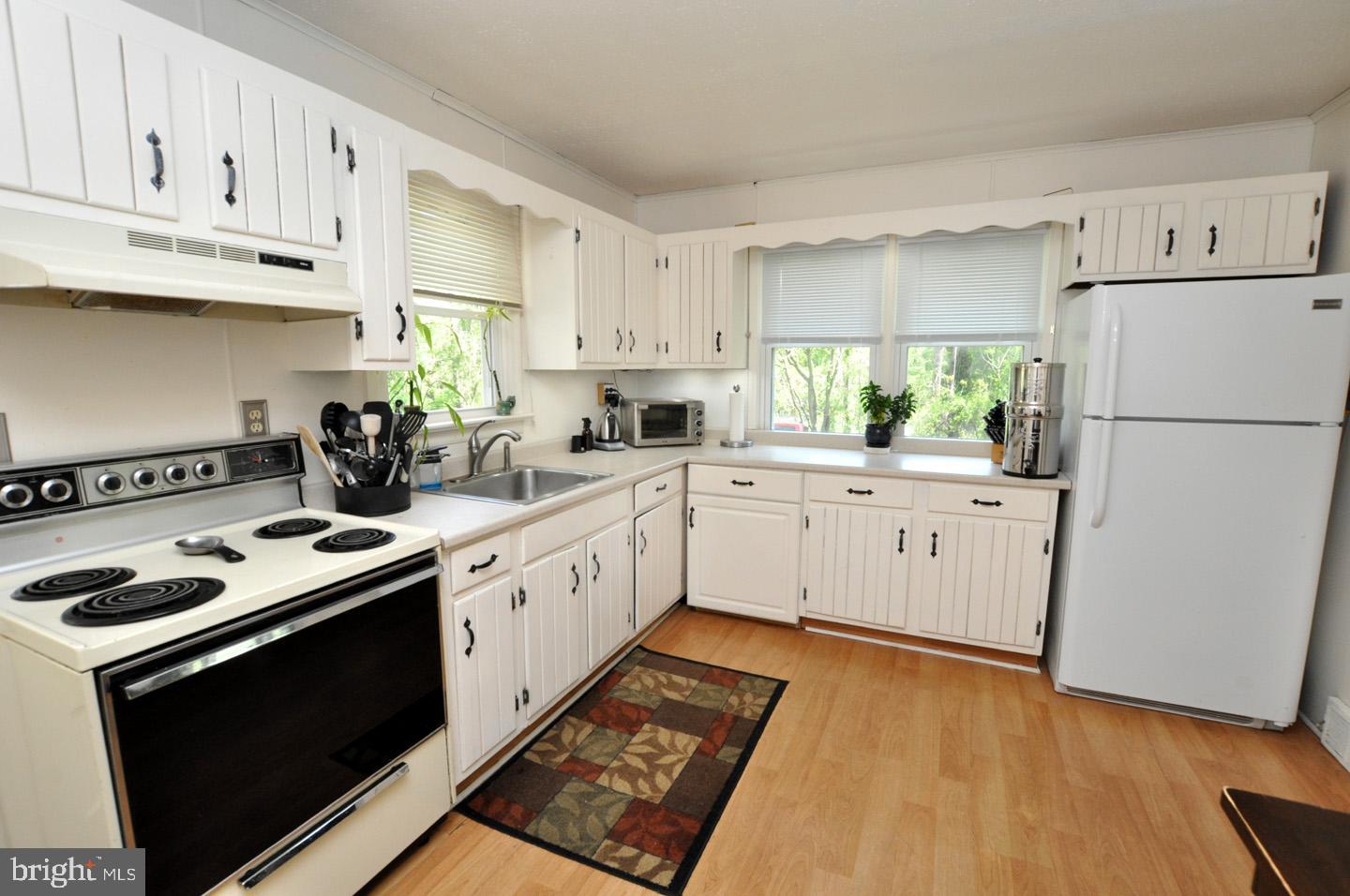 607 North Broad Street Hainesport, NJ 08036 - Photo 6 of 24 a kitchen with a white cabinets and white appliances