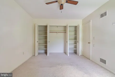 a view of an empty room with a ceiling fan