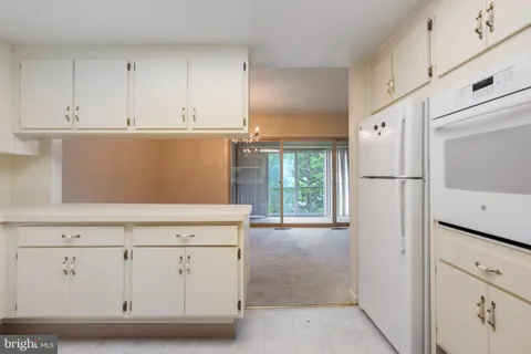 a kitchen with white cabinets and white appliances