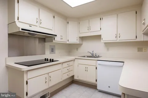 a kitchen with white cabinets and sink
