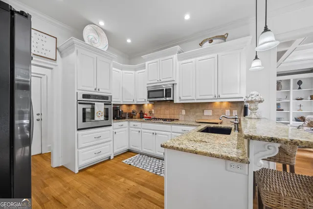 a kitchen with stainless steel appliances granite countertop a refrigerator and a sink