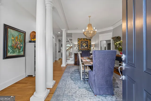 a dining room with furniture a chandelier and wooden floor