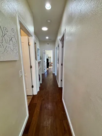 a view of a hallway with wooden floor and staircase