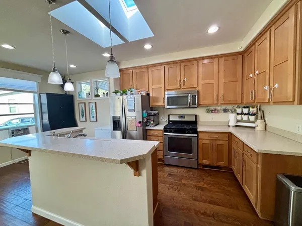 a kitchen with granite countertop a sink stainless steel appliances and cabinets