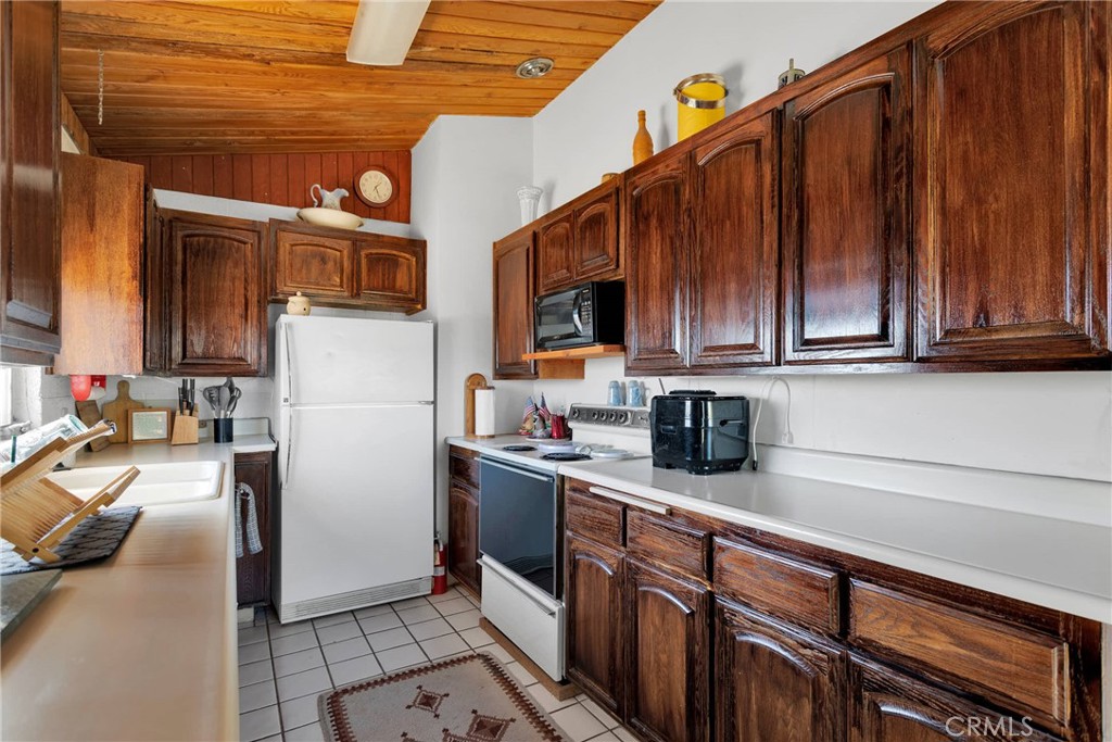 9482 Palomar Trail Lucerne Valley, CA 92356 - Photo 10 of 45 a kitchen with stainless steel appliances granite countertop a refrigerator and a stove top oven