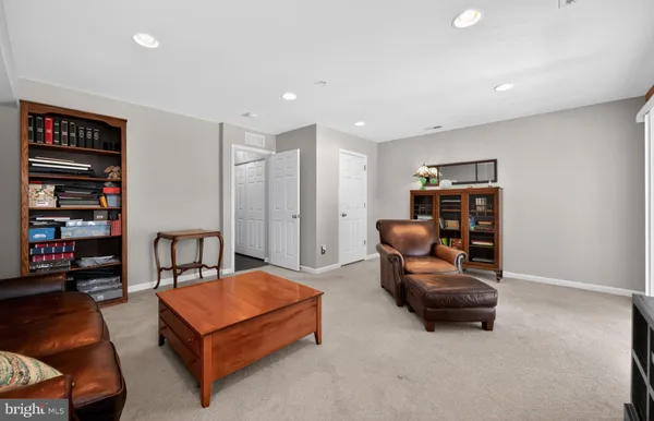 a living room with furniture a ceiling fan and a book shelf