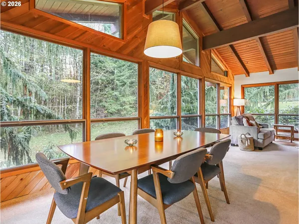 a dining room with furniture and a floor to ceiling window