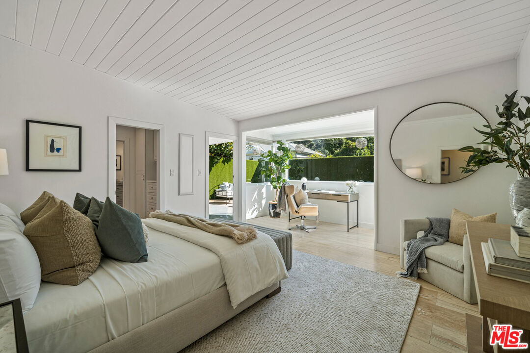 9614 Heather Road Beverly Hills, CA 90210 - Photo 1 of 1 a spacious bedroom with a bed a mirror and a large window