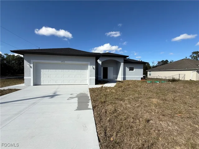 a front view of a house with a yard and garage