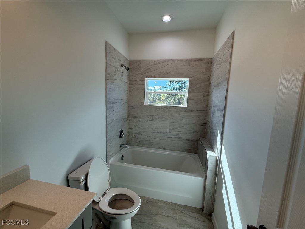 1853 Norma Court Lehigh Acres, FL 33972 - Photo 12 of 19 a bathroom with a bathtub and a toilet