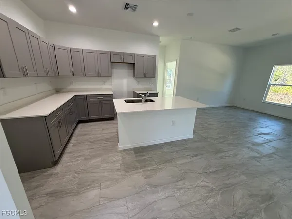 a kitchen with granite countertop a sink a stove a refrigerator and a cabinets