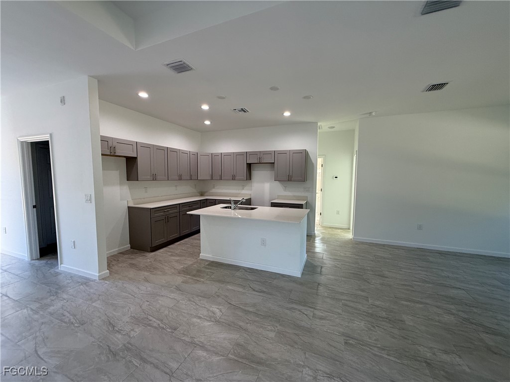 1853 Norma Court Lehigh Acres, FL 33972 - Photo 5 of 19 a large kitchen with a large counter top a sink stainless steel appliances and cabinets