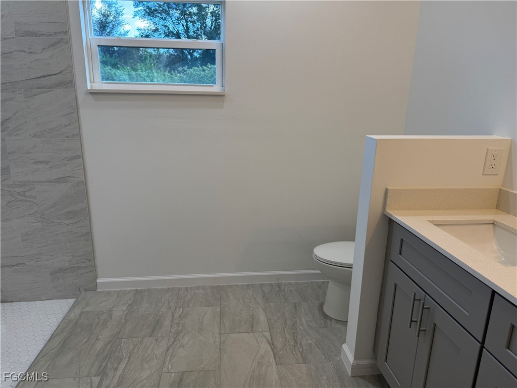 1853 Norma Court Lehigh Acres, FL 33972 - Photo 9 of 19 a bathroom with a granite countertop toilet and a sink