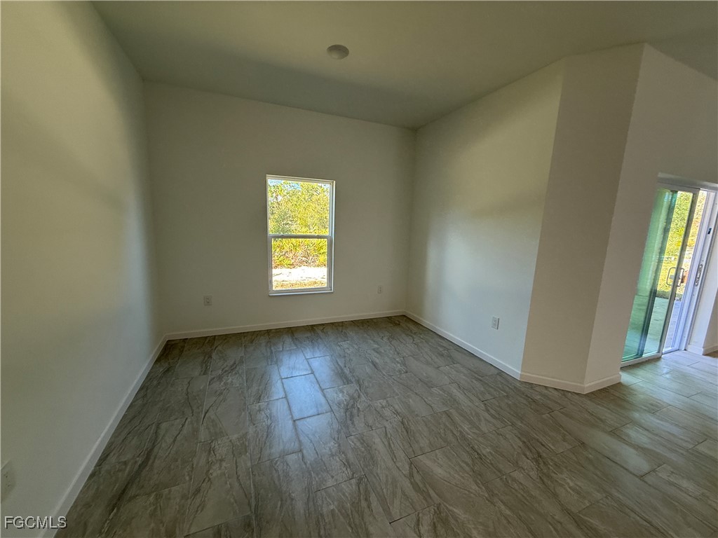 1853 Norma Court Lehigh Acres, FL 33972 - Photo 10 of 19 an empty room with wooden floor and windows