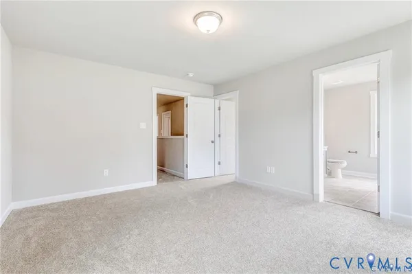 a view of an empty room with windows and closet