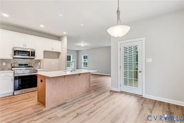 a kitchen with a sink cabinets and wooden floor