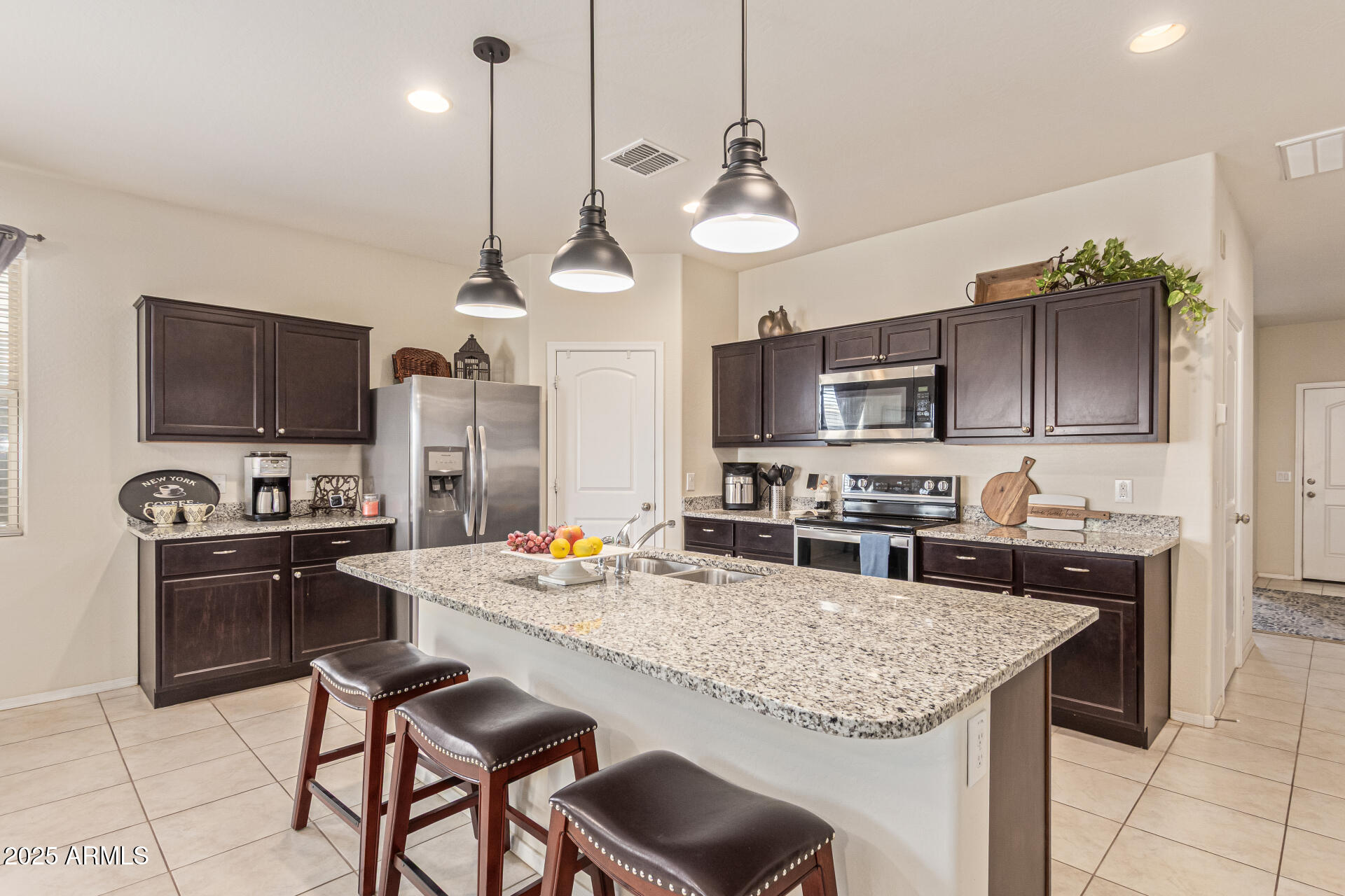 41844 West Rosa Drive Maricopa, AZ 85138 - Photo 3 of 47 a kitchen with stainless steel appliances granite countertop a stove top oven a refrigerator a sink dishwasher a dining table and chairs with wooden floor