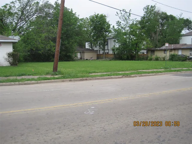 a view of a road with a house in the background