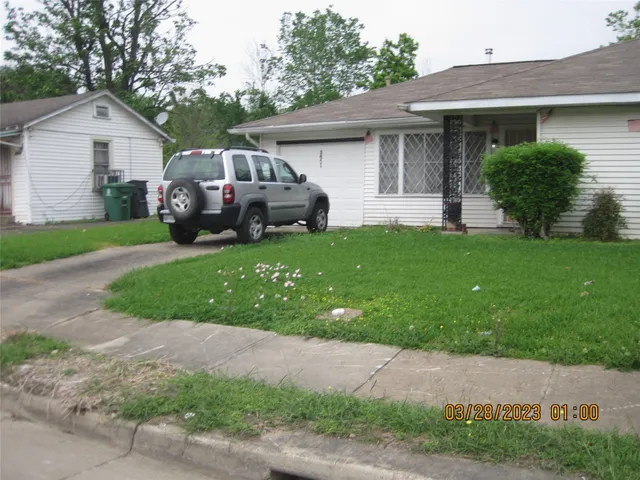 a front view of a house with a garden and trees