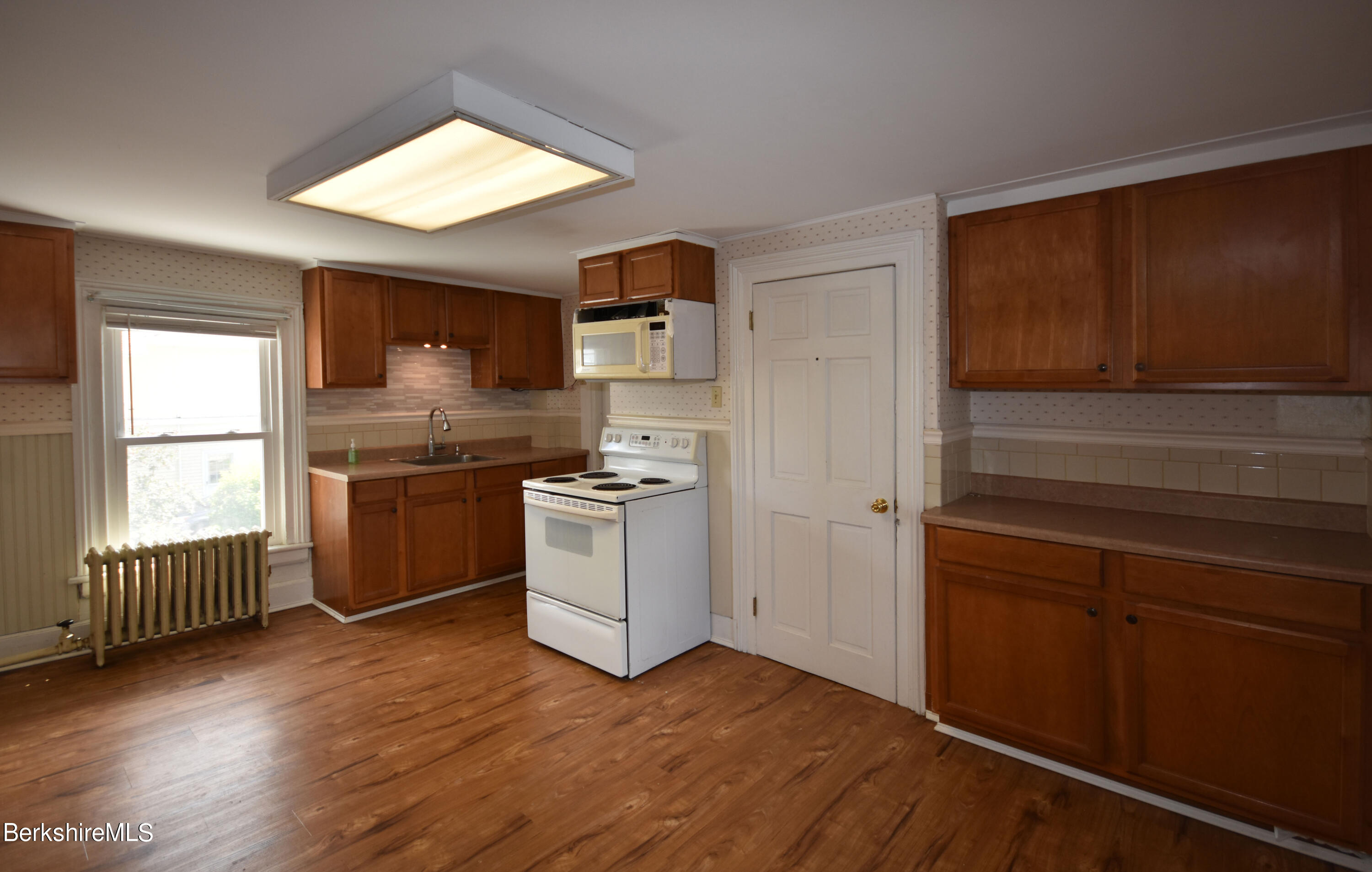 26 Elizabeth Street Pittsfield, MA 01201 - Photo 25 of 43 a kitchen with granite countertop white cabinets and white appliances
