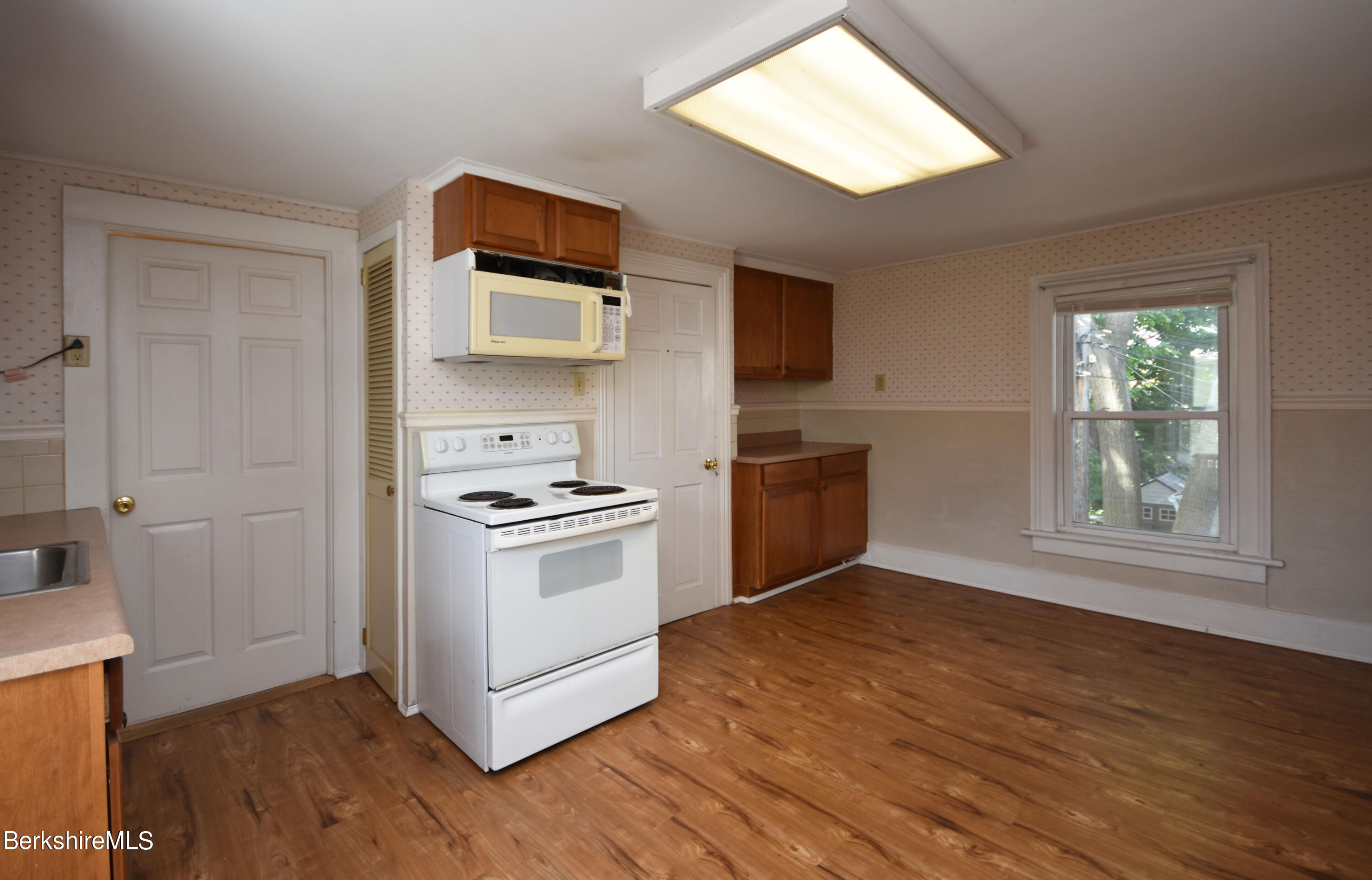 26 Elizabeth Street Pittsfield, MA 01201 - Photo 27 of 43 a kitchen with wooden floors and white stainless steel appliances