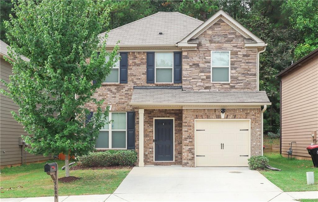 a front view of a house with a yard and garage