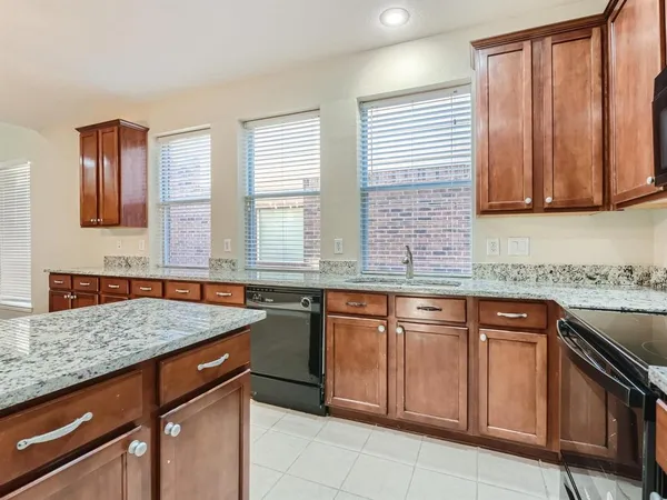 a kitchen with stainless steel appliances granite countertop a sink stove and cabinets