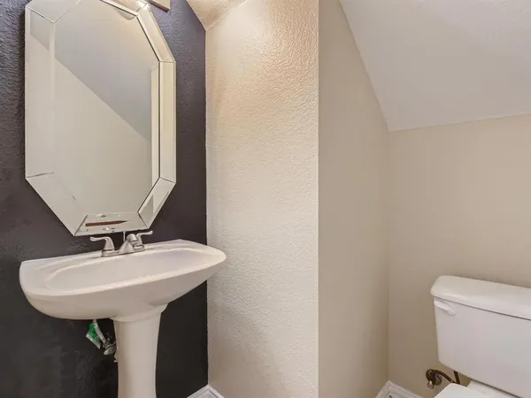 a bathroom with a sink a toilet and mirror