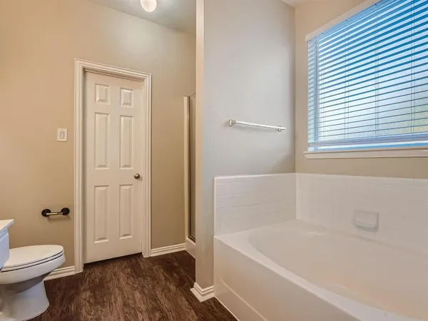 a bathroom with a granite countertop bathtub shower and toilet