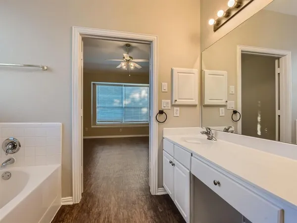 a bathroom with a tub a sink and mirrors