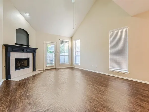 a view of an empty room with a fireplace and a window