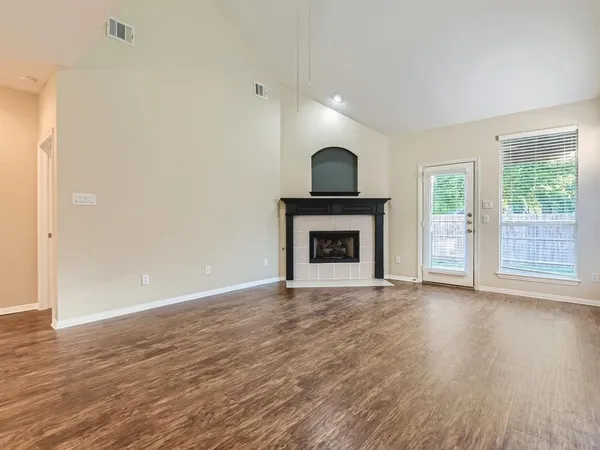 a view of empty room with wooden floor and fireplace