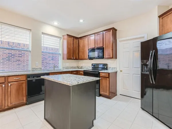 a kitchen with stainless steel appliances granite countertop a stove a sink dishwasher a refrigerator and a microwave oven