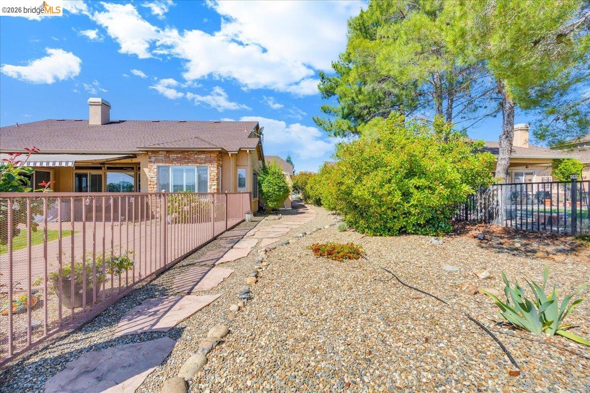 158 Rock Ridge Lane Copperopolis, CA 95228 - Photo 57 of 72 Exterior patio with a retractable awning, surrounded by a metal fence
