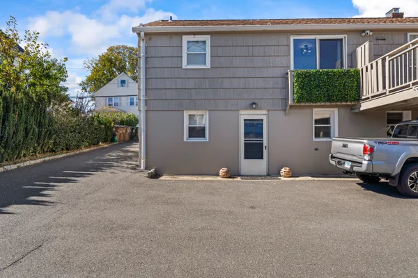 a view of a house with a yard and parking space