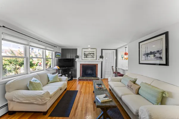 a living room with furniture a large window and a fireplace