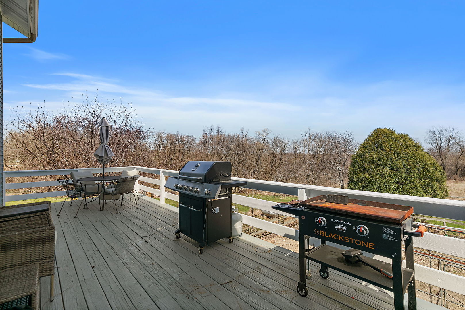 9602 Wright Road Harvard, IL 60033 - Photo 16 of 26 a view of a roof deck with table and chairs a barbeque with wooden floor and fence
