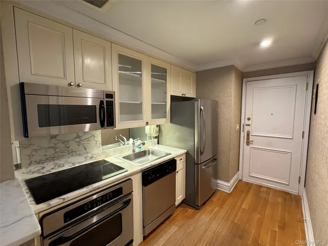 a kitchen with stainless steel appliances a stove a microwave and a refrigerator