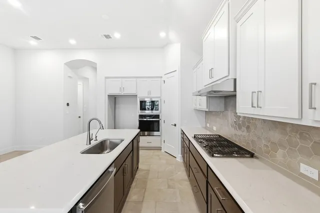 a kitchen with sink stove and cabinets