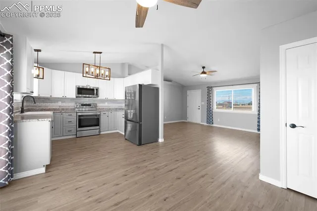 a kitchen with stainless steel appliances granite countertop a refrigerator and a stove top oven