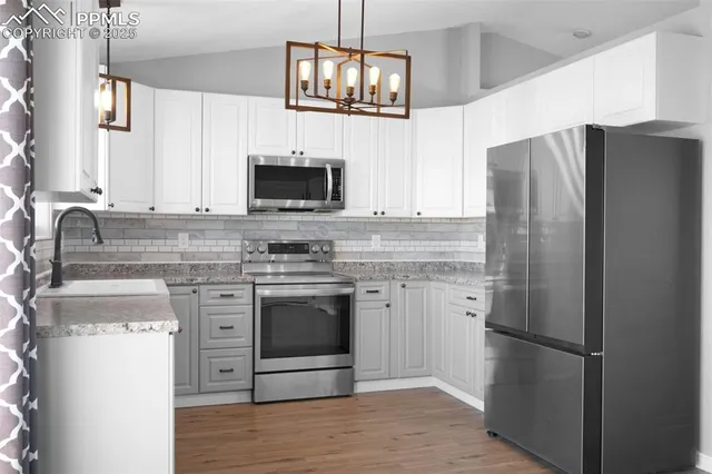a kitchen with stainless steel appliances granite countertop a refrigerator stove and microwave