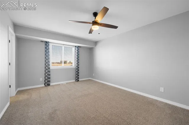 an empty room with closet and windows