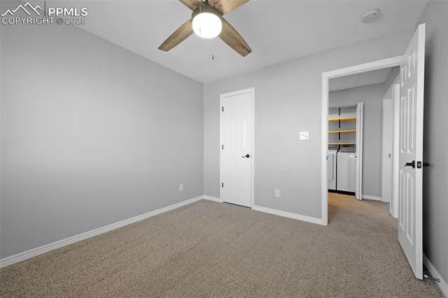 an empty room with closet and a chandelier fan